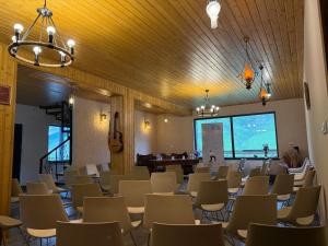 a room with a bunch of chairs and a piano at Guesthouse Angelina in Ushguli