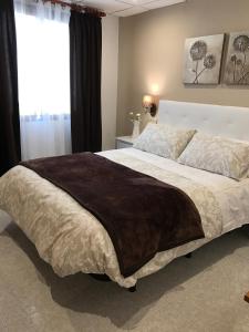 Un dormitorio con una cama grande con una manta marrón. en Hostal Alcázar, en Toledo