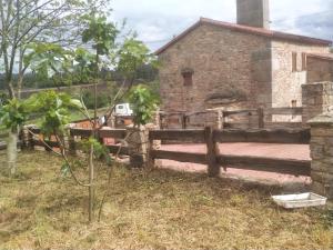 an old stone house with a wooden fence at Villa Careixo in Castro