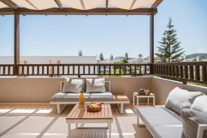 a balcony with two couches and a table at Erato Beach Hotel Adults Only by Smile Hotels in Platanias
