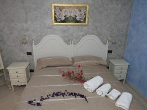 a bedroom with a white bed with flowers on it at B&B La Maison in Potenza