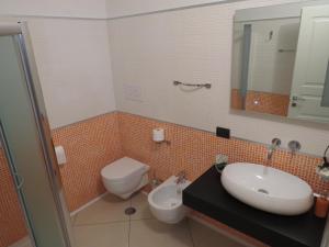 a bathroom with a sink and a toilet and a mirror at B&B La Maison in Potenza