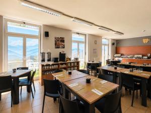 ein Restaurant mit Tischen und Stühlen in einem Raum in der Unterkunft Phi Hotel Homy Druento in Druento