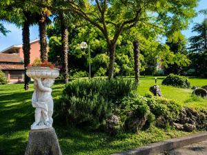 ein steinerner Pflanzkübel mit Blumen in einem Park in der Unterkunft Phi Hotel Homy Druento in Druento