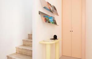 a hallway with a yellow table and stairs at Duesette Rooms in Filottrano +7 photos