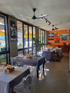 a dining room with two tables and chairs and windows at BARRYDALE Karoo - BOUTIQUE HOTEL in Barrydale