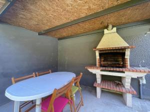 a table and chairs with a fireplace on a patio at Geres - Gateway House - Terras de Bouro in Terras de Bouro