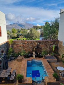 a backyard with a swimming pool and a brick wall at BARRYDALE Karoo - BOUTIQUE HOTEL in Barrydale