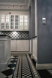 a kitchen with a black and white checkered floor at Royal Residence by OTR in Krakow