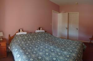 a bedroom with a bed with a blue comforter at Bleantis Mountain Cottage in the Comeragh Mountains in Dungarvan