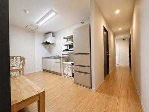 a kitchen with a refrigerator and a wooden floor at D Hotel - Vacation STAY 14103v in Tokyo