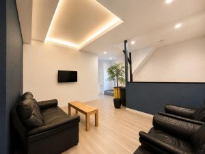 a living room with two leather chairs and a tv at D Hotel - Vacation STAY 78387v in Tokyo