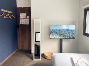 a bedroom with a tv hanging on the wall at D Hotel - Vacation STAY 89642v in Tokyo