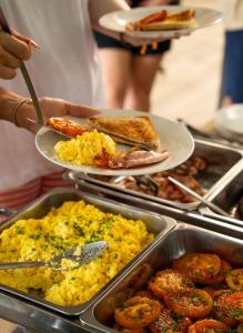 a person holding a plate of breakfast food with toast at SleepOver Phabeni in Hazyview