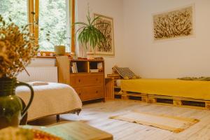 a living room with a yellow bed and a window at DobroDziejnia in Nowa Ruda