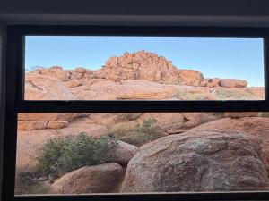 a view of a rocky mountain from a window at Sky and Stone Tented Camps in Twyfelfontein +2 photos