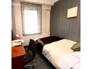 a bedroom with a bed and a desk and a window at Central Hotel - Vacation STAY 99763v in Kusugaurachō