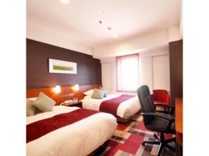 a hotel room with two beds and a desk at Central Hotel - Vacation STAY 99769v in Kusugaurachō