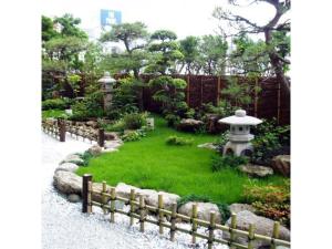 a garden with a stone fence and a japanese garden at Central Hotel - Vacation STAY 99770v in Kusugaurachō