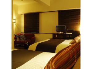 a hotel room with two beds and a television at Central Hotel - Vacation STAY 99767v in Kusugaurachō