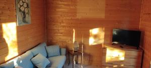 a living room with a blue couch and a television at Chalet brumalis in Le Malzieu-Ville +8 photos