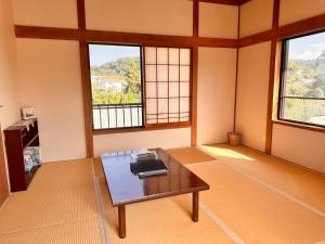 a living room with a table and two windows at kupono - Vacation STAY 00621v in Minamiboso