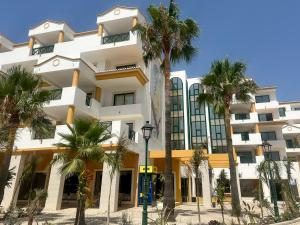 a building with palm trees in front of it at Balaia Plaza in Albufeira