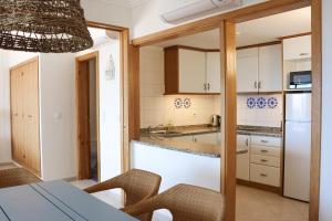 a kitchen with white cabinets and a table and chairs at Balaia Plaza in Albufeira +41 photos