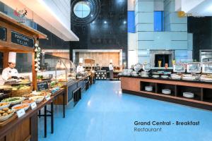 a restaurant with a buffet line with people preparing food at Merlynn Park Hotel in Jakarta