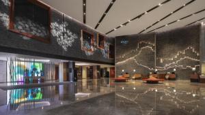 a lobby of a building with tables and chairs at Renaissance Xi'an Hotel in Xi'an