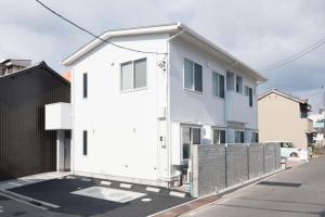 a white house sitting on the side of a street at HOTEL PG -2- - Vacation STAY 38330v in Onomichi