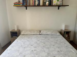 a bed in a bedroom with two shelves on the wall at Bilocale con terrazzo in centro storico in Dorgali