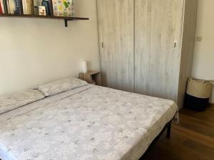 a bedroom with a bed with a white comforter at Bilocale con terrazzo in centro storico in Dorgali