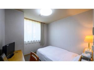 a room with a bed and a desk and a television at Hotel Symphony - Vacation STAY 37099v in Sagae