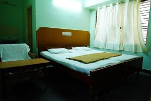 a bedroom with a bed with a blanket on it at Balaji inn in Anantapur