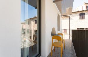 a balcony with two yellow chairs and a window at Duesette Rooms in Filottrano