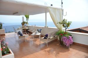 un patio avec une table et des chaises sur un balcon dans l'établissement L'Attico, à Taormine