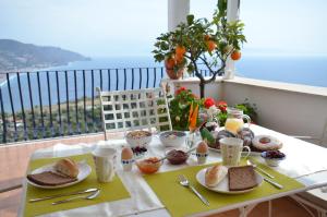 stół z jedzeniem i widokiem na ocean w obiekcie Apartment L'Attico w Taominie