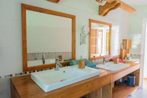 a bathroom with two sinks and a large mirror at Le palmier d'Alice in Collonges