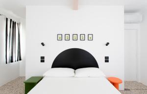 a bedroom with a white bed with a black headboard at Duesette Rooms in Filottrano