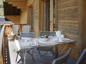 a table on a porch with a bowl of fruit on it at Apartment Baudrier A28 by Interhome in Verbier