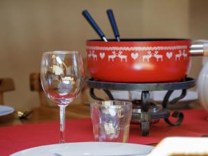 a table with two wine glasses and a pot on a table at Apartment Baudrier A28 by Interhome in Verbier +30 photos
