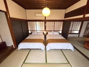 a bedroom with two beds in a room with windows at Sakae - Vacation STAY 41407v in Goto