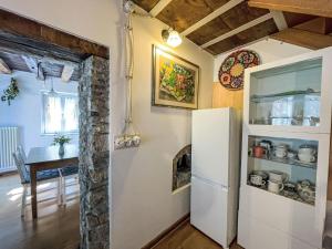 a kitchen and dining room with a refrigerator and a table at Holiday Home Casa Lienartova by Interhome in Grimacco