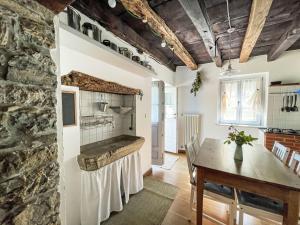 a kitchen with a table and a stone wall at Holiday Home Casa Lienartova by Interhome in Grimacco