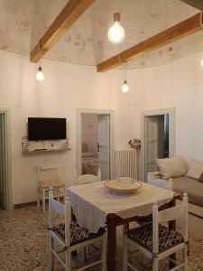 a living room with a table and a couch at Trullo Le Tre Sorelle in Cisternino
