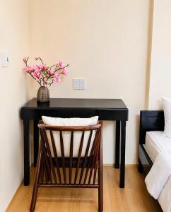 a black desk with a vase of flowers on it at Hue Ancient Hostel in Hue +20 photos
