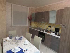 a kitchen with a table and chairs and a kitchen with a counter at B&B La Maison in Potenza
