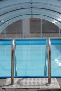 - une piscine avec deux bars en métal devant dans l'établissement HOTEL RESTAURANT LE SAINT PIERRE "Grand Périgueux", à Saint-Pierre-de-Chignac