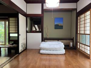 a living room with a white ottoman on a wooden floor at 8co - Vacation STAY 69979v in Chino